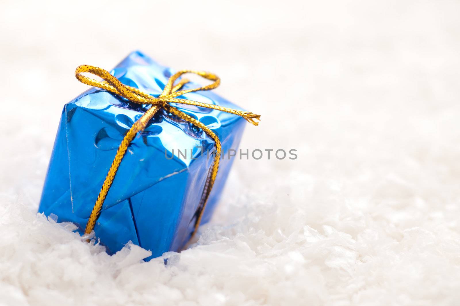 blue christmas gift in the snow with copytext