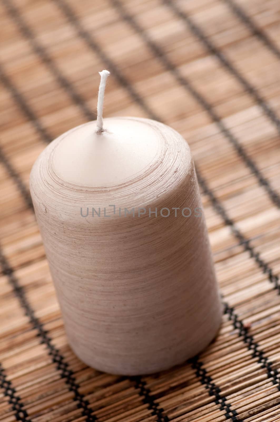 Candle on a brown background with shallow depth of field