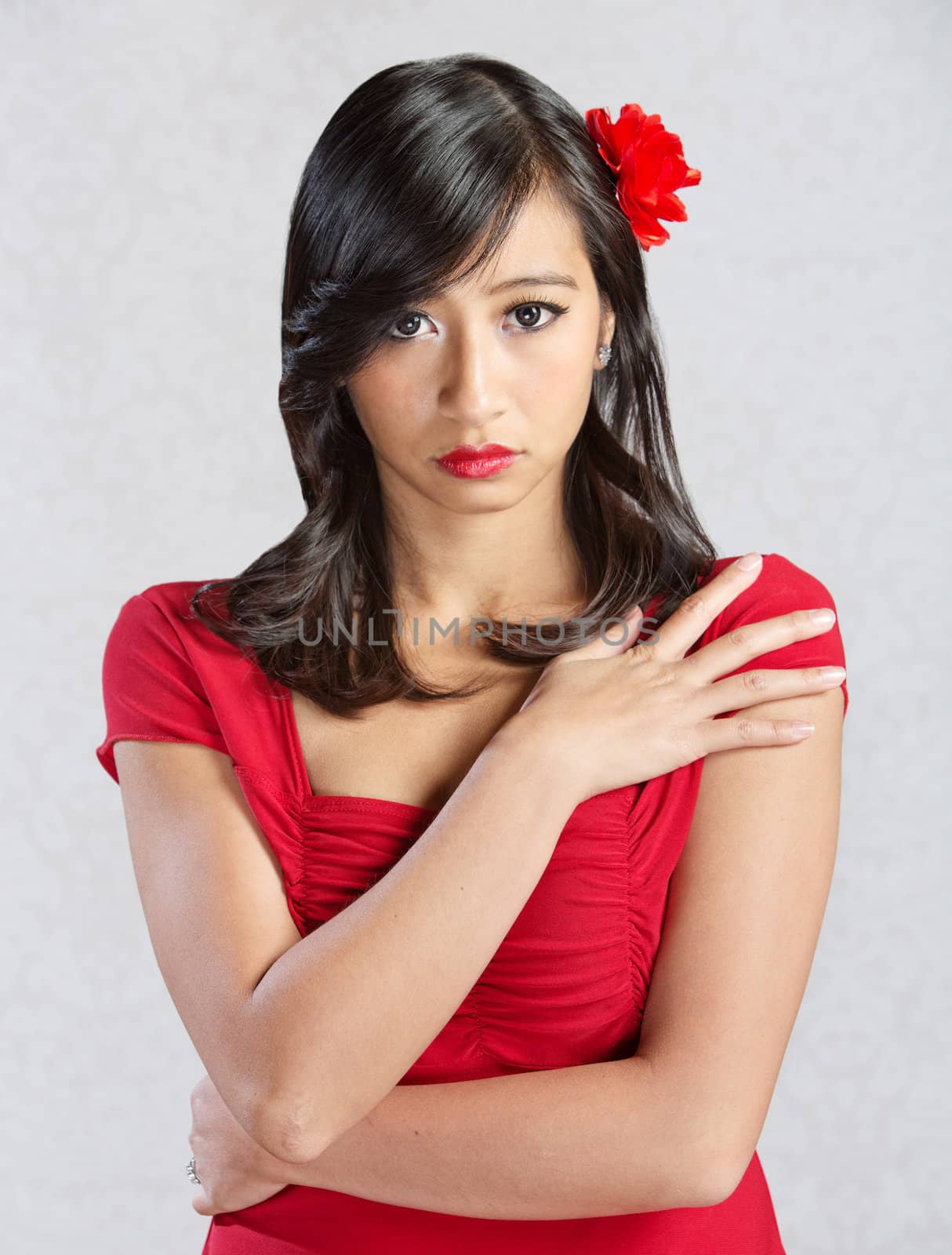 Beautiful young Asian woman with red flower in hair