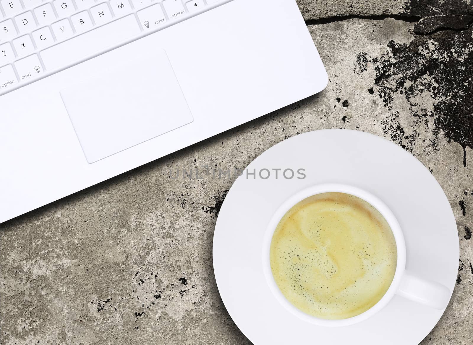 Laptop and coffee cup on old concrete surface. Computer technology concept