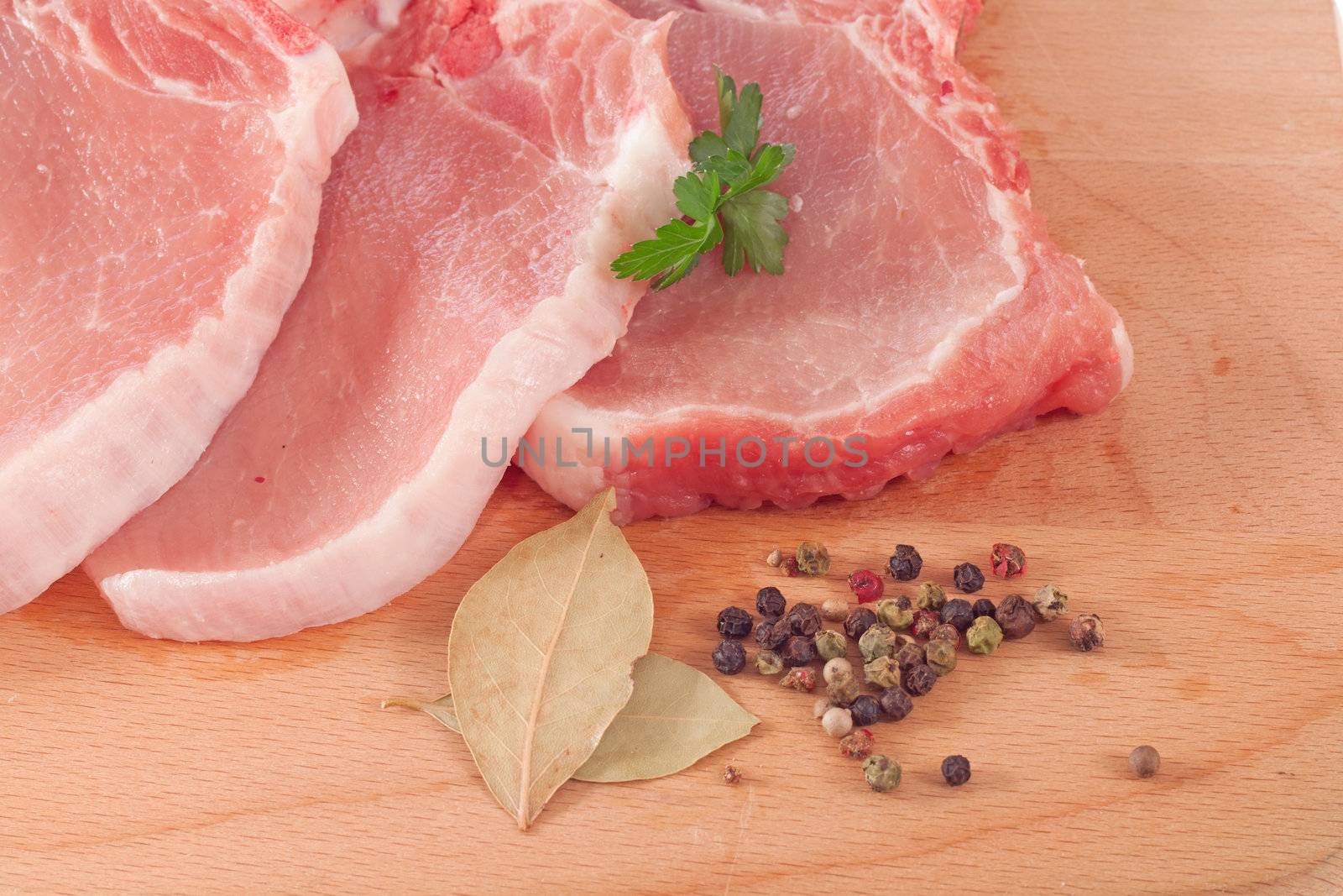 Pork chop and spices on a cutting board