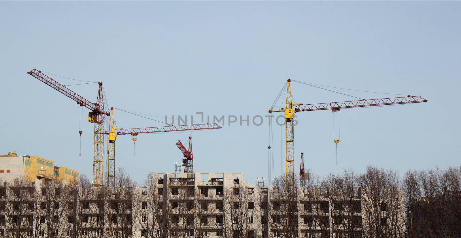 Inside place for many tall buildings under construction and cranes under a blue sky