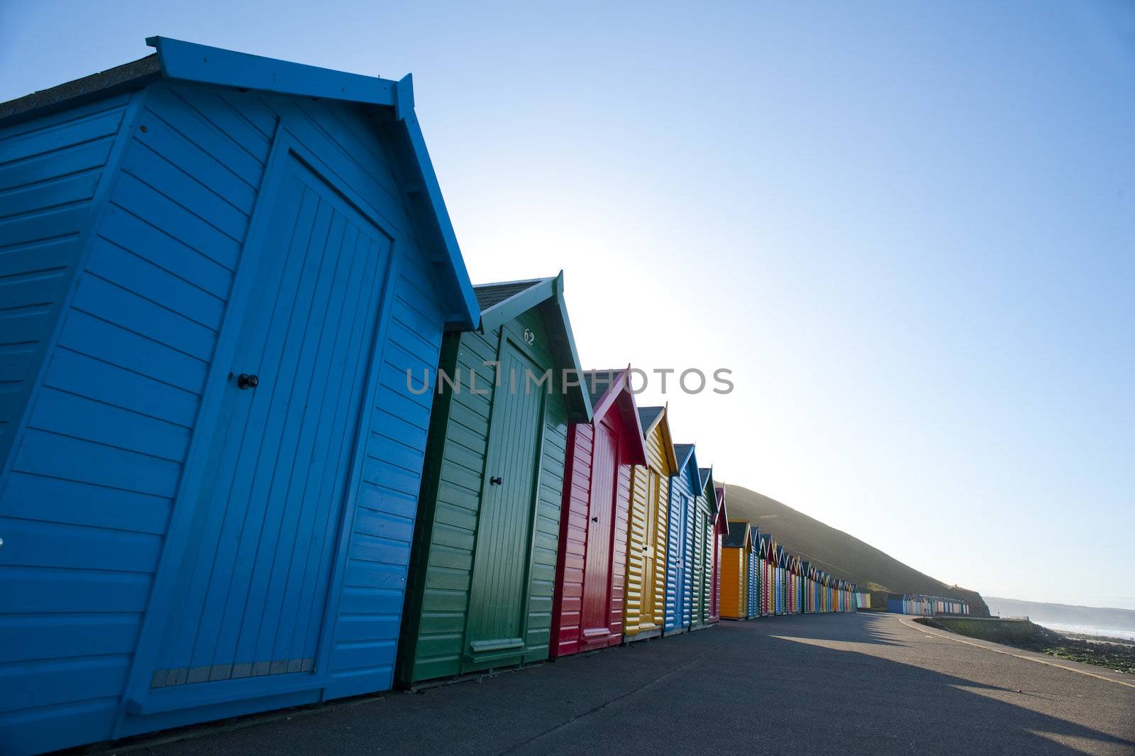 Row of colorful wooden beach huts in Whitby by stockarch