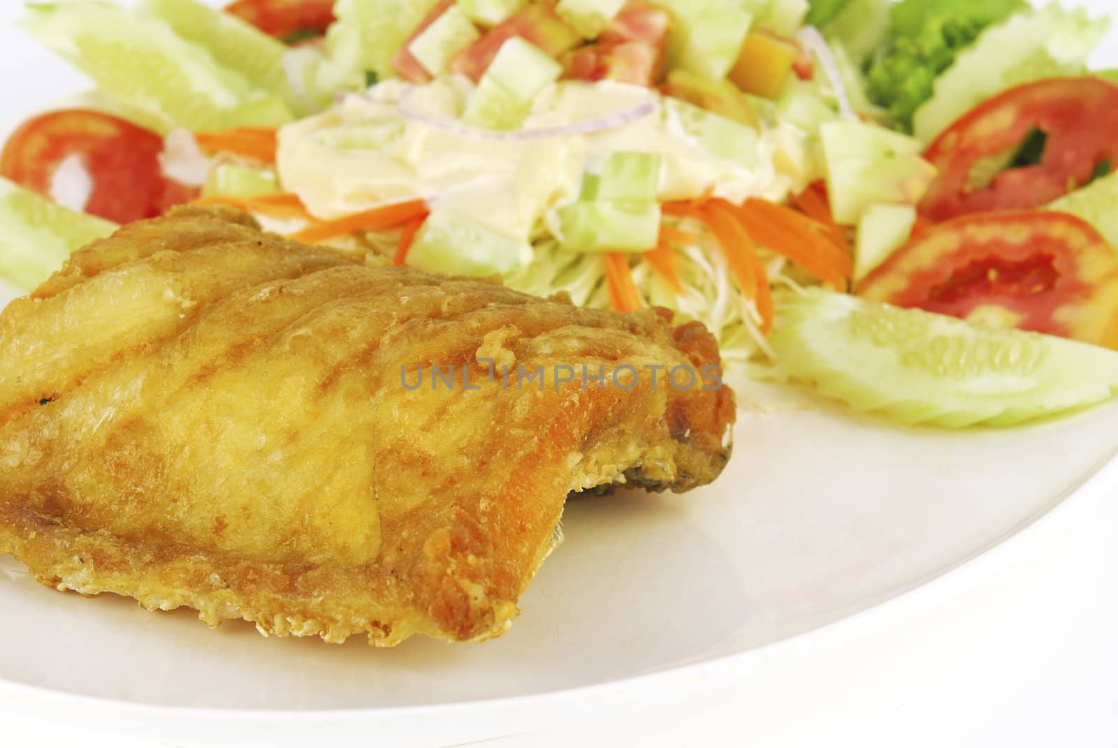 Fish dish - deep fried fish with vegetable salad on white