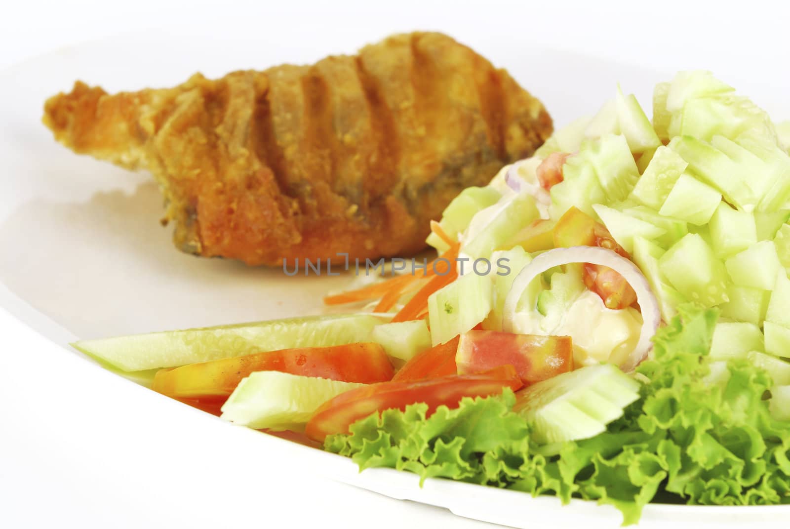 Fish dish - deep fried fish with vegetable salad on white