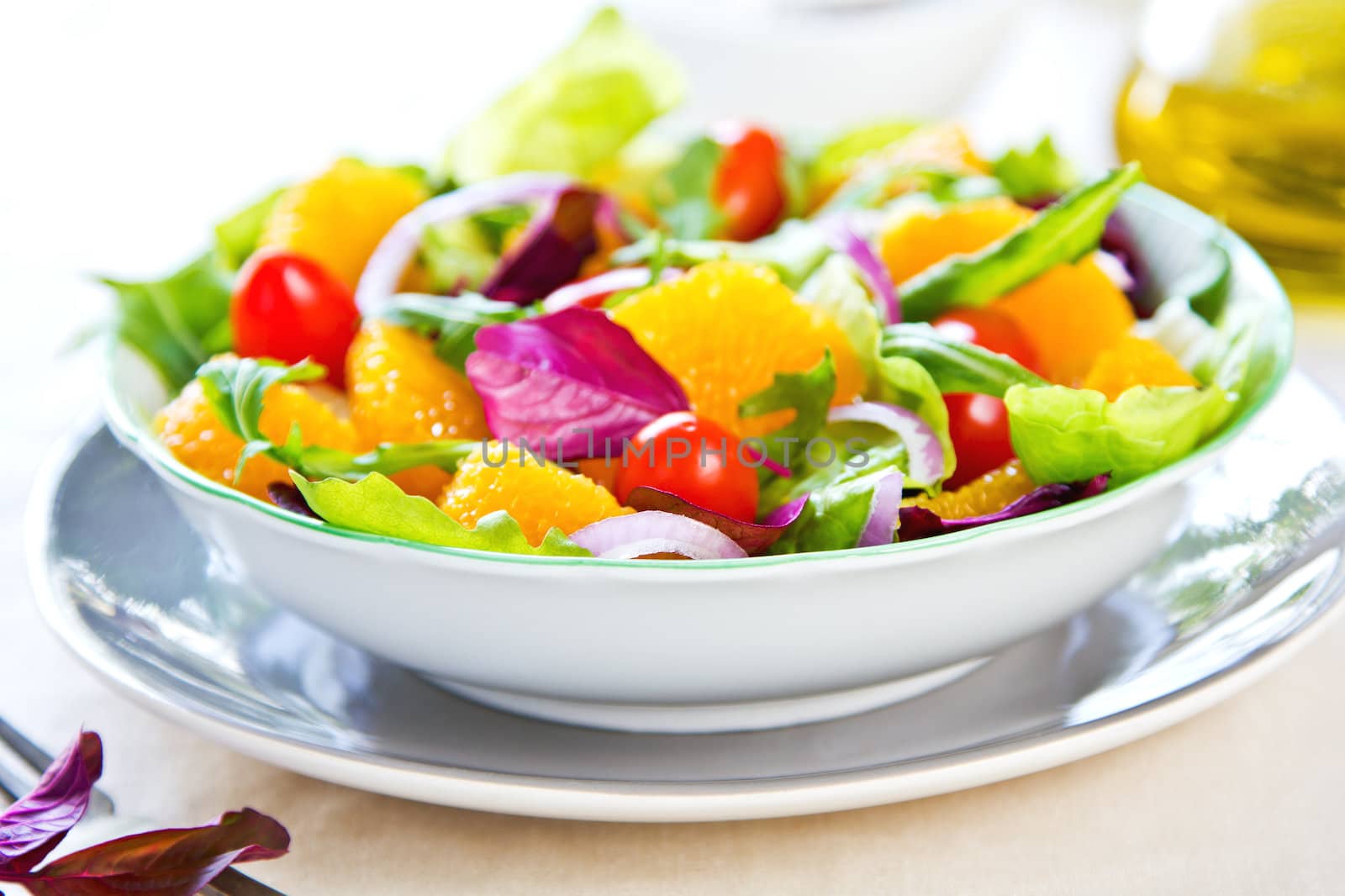 Orange with rocket and lettuce salad in a bowl,