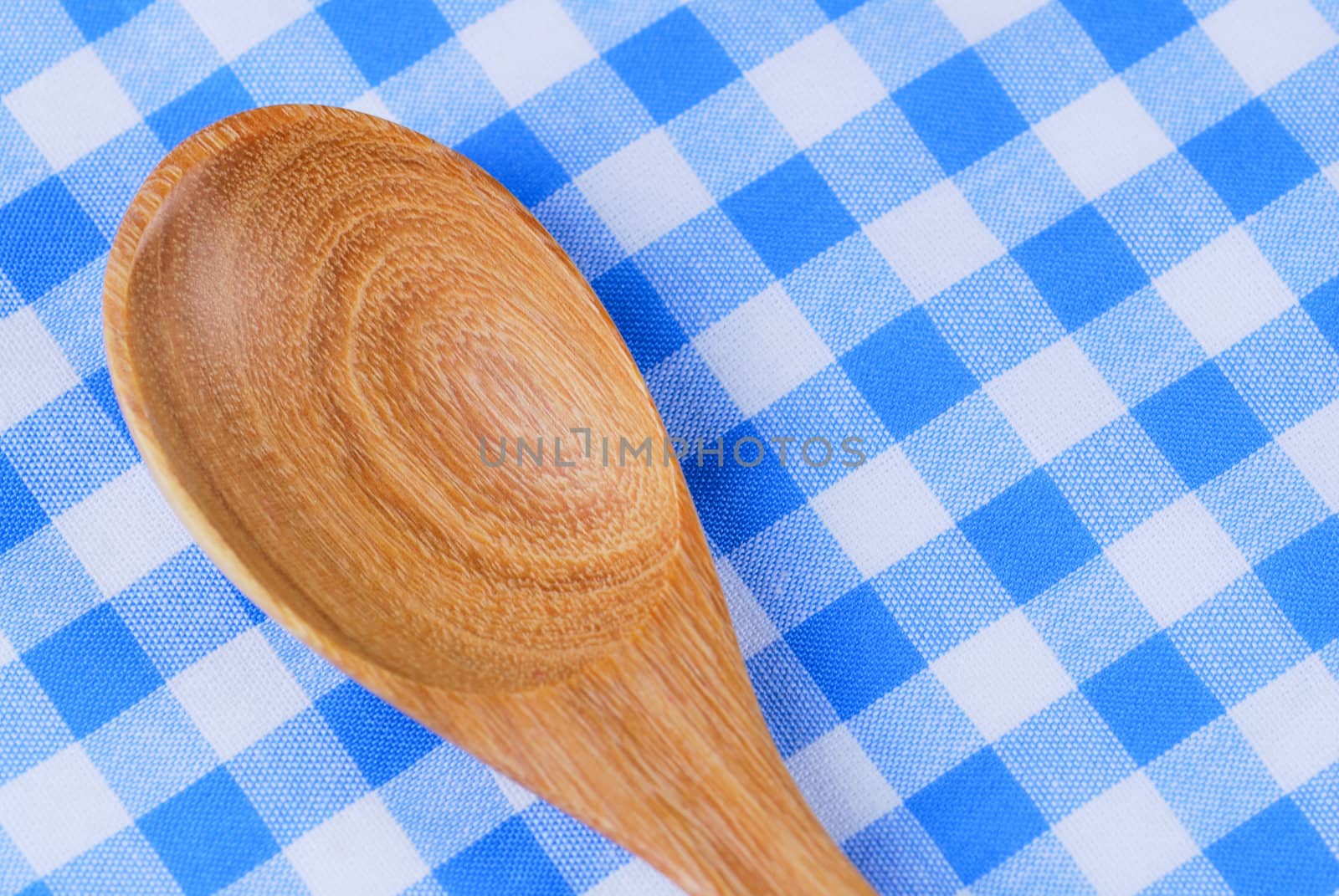 Wooden spoon,  tablecloth, fork on table background