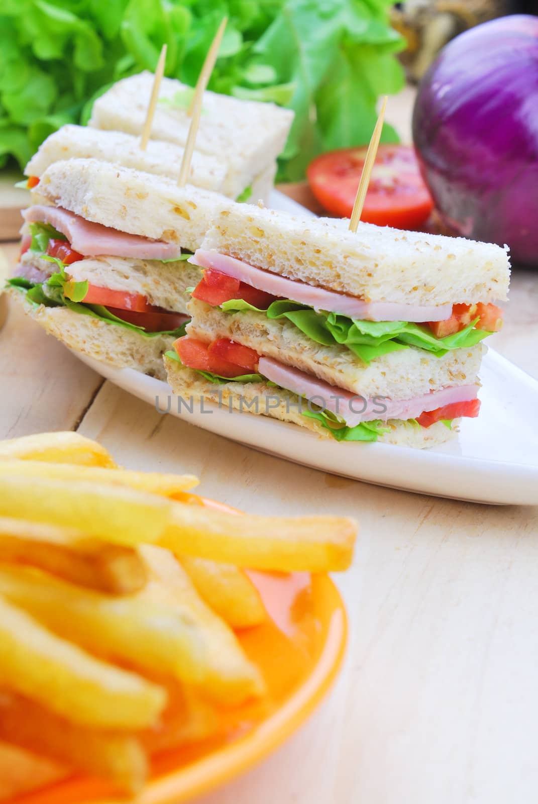 Club Sandwich with Cheese, Pickled Cucumber, Tomato and ham. Garnished with French Fries