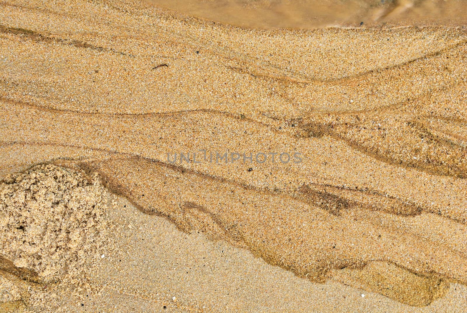 Texture of sand and waste water leak on beach .