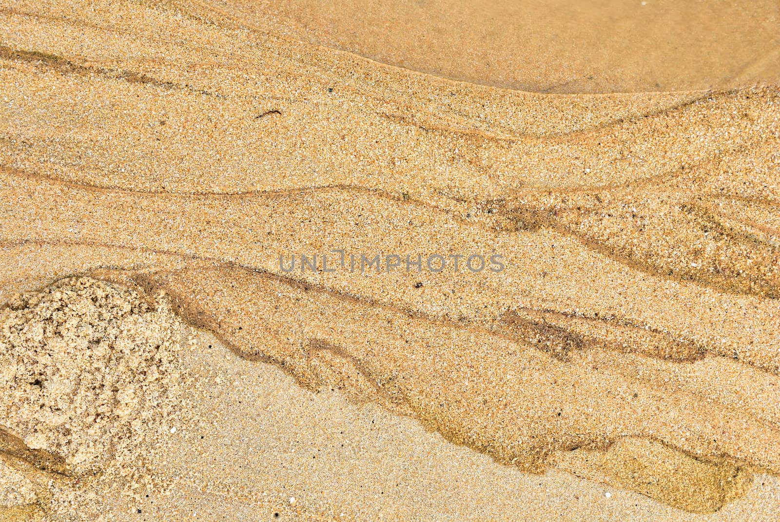 Texture of sand and waste water leak on beach .