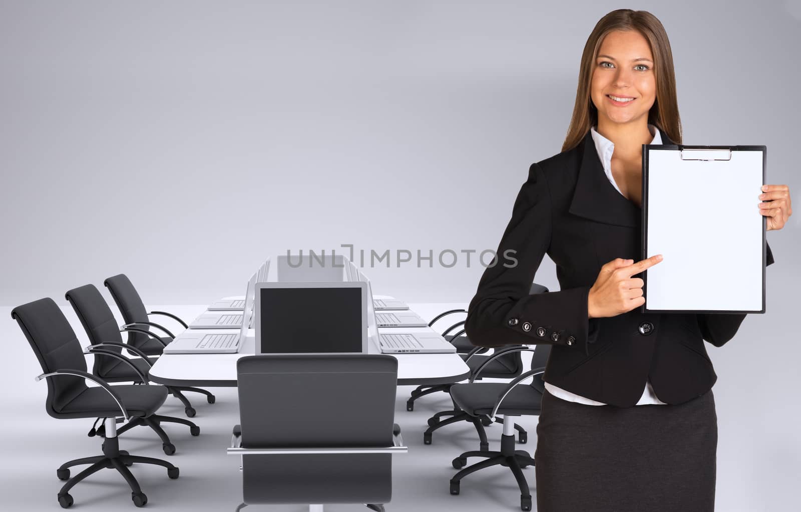 Businesswoman holding paper holder. Conference table, chairs and laptops as backdrop