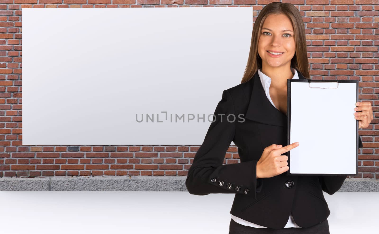 Businesswoman holding paper holder. Brick wall and white placard as backdrop