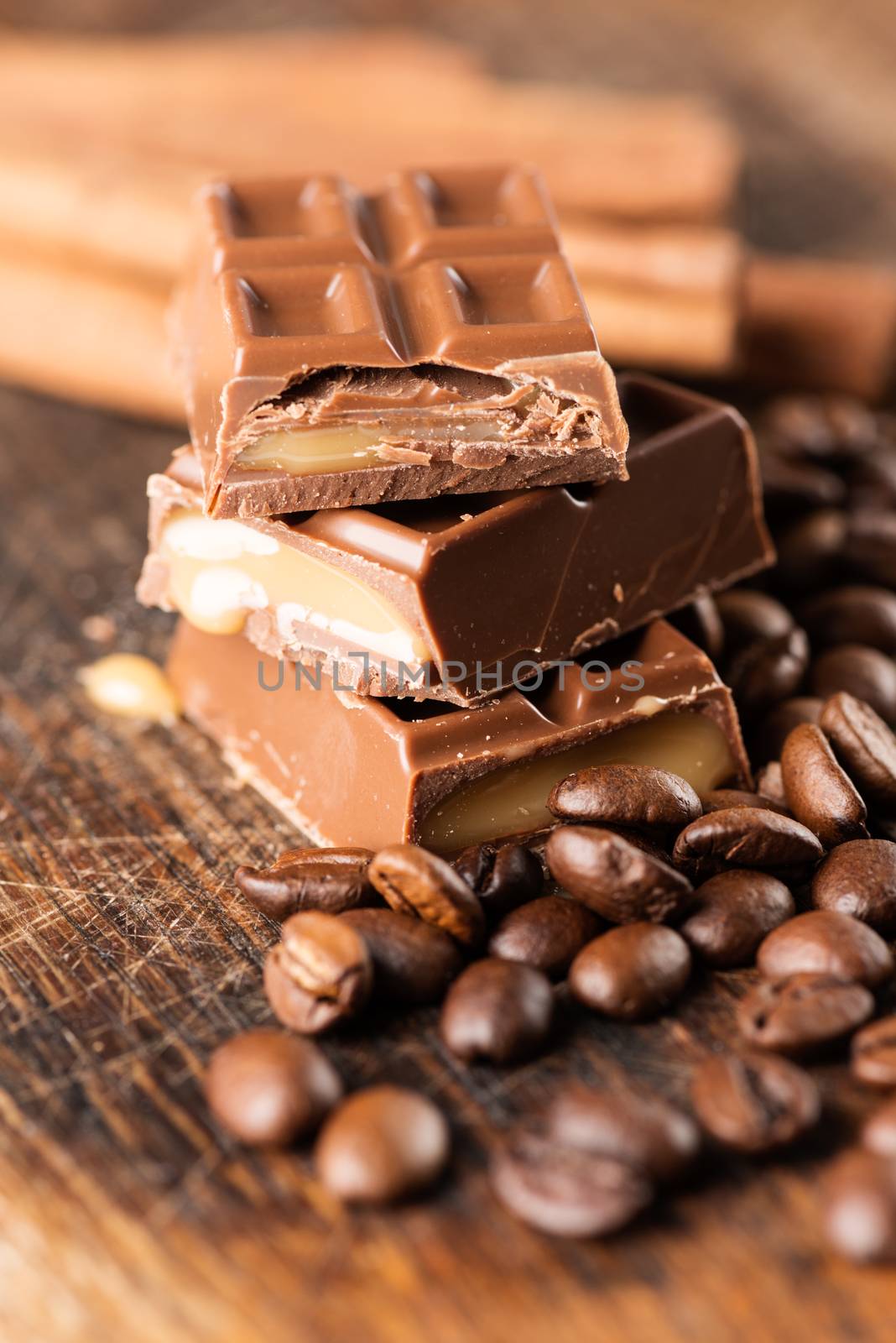 Coffee beans with chocolate bar on wooden table