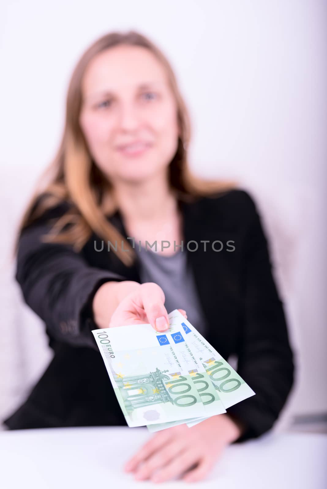 Defocused young woman offering money