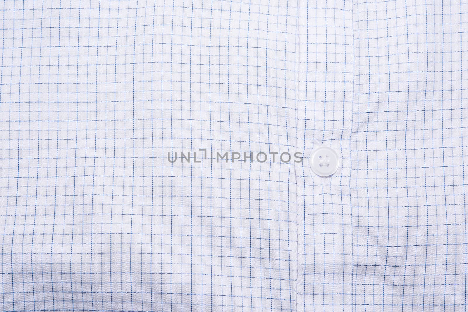 Close-up photograph of a white button on a striped shirt pattern.