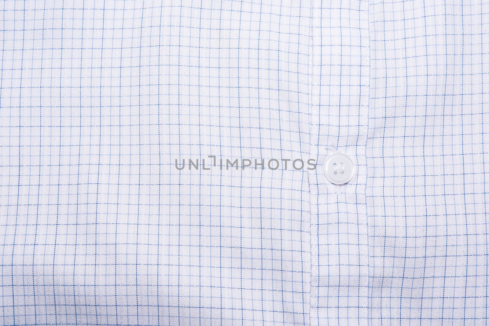 Close-up photograph of a white button on a striped shirt pattern.