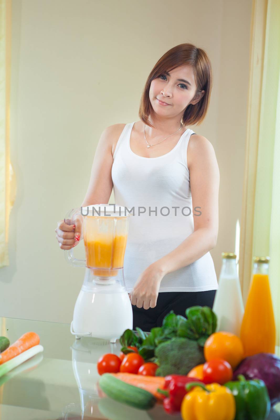 Beautiful Young Asian Woman Making Fruit Smoothie in Blender