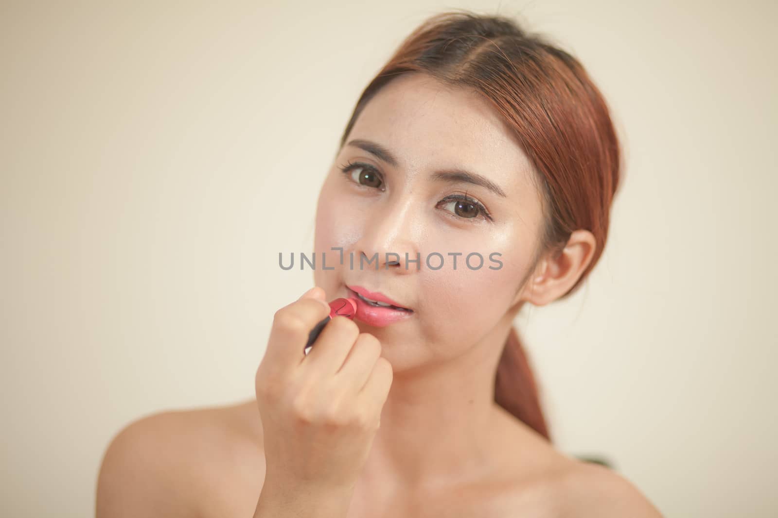 Beauty asian woman applying lipstick on lips isolated