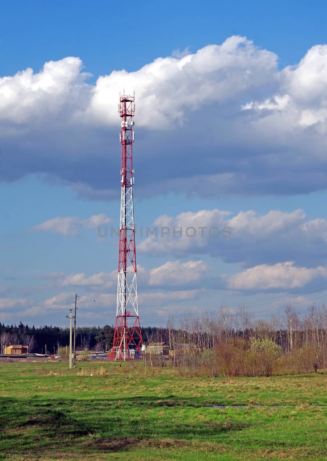 Cellular tower on a background of spring landscape                               