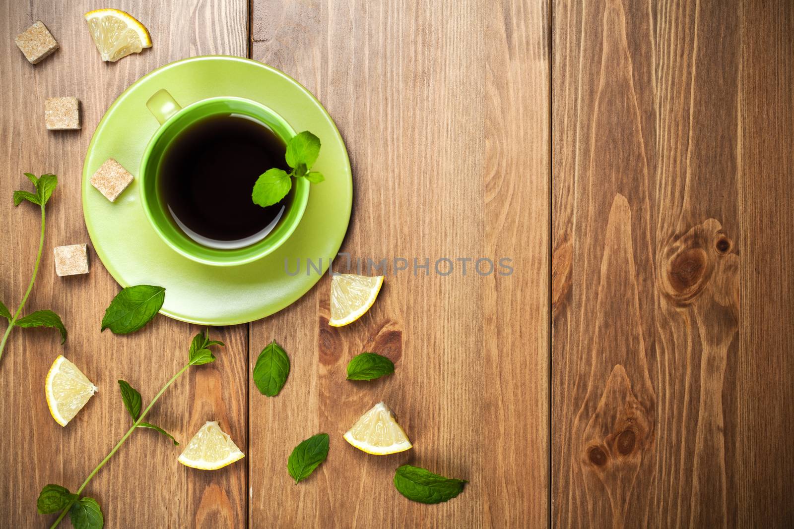 Tea mint with mint leaves, sugar and lemon on table background. Copy space. Top view. Focus on table
