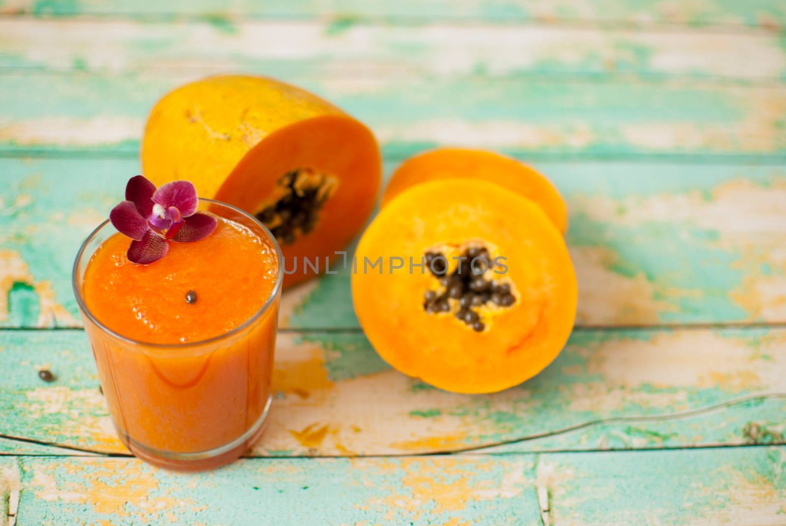 healthy fresh papaya smootie juice on wooden green boards