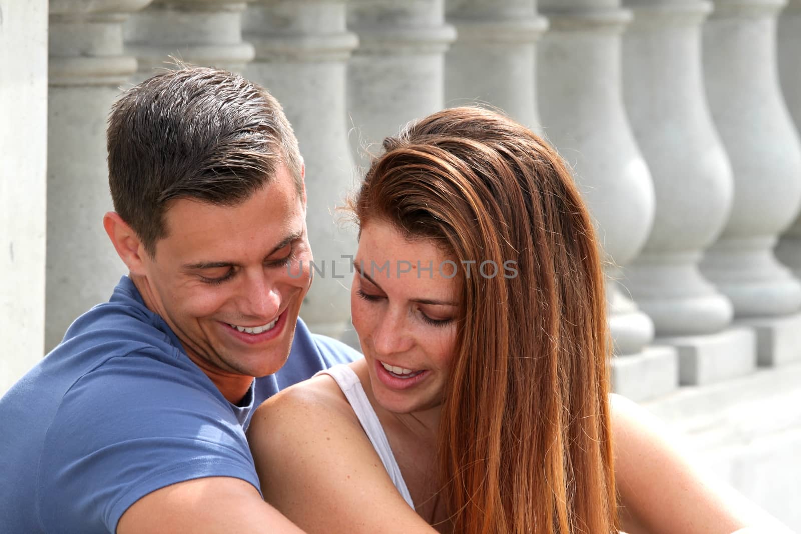 Young couple sitting on a bridge.