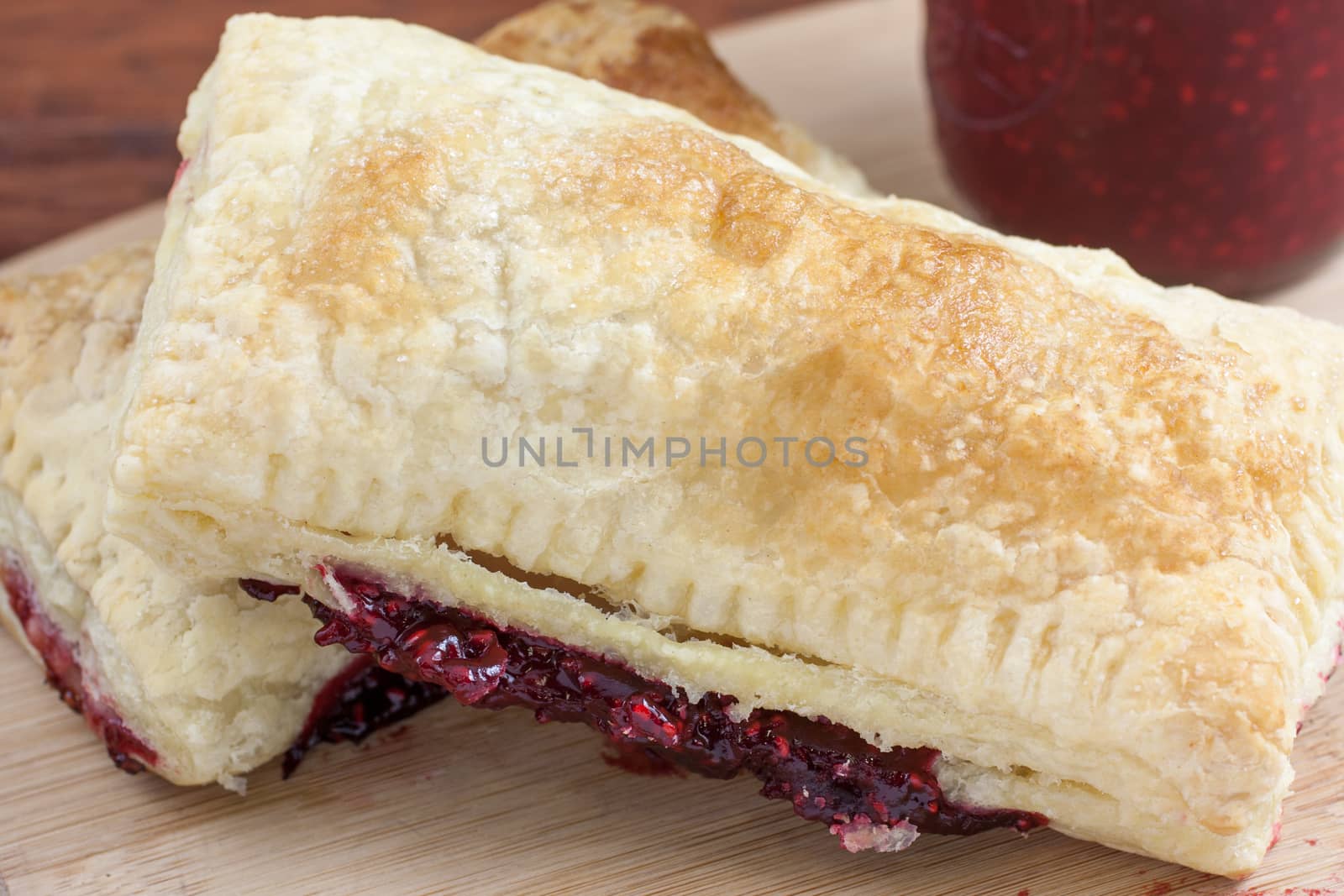 Fresh raspberry turnovers on a table sitting in natural light.