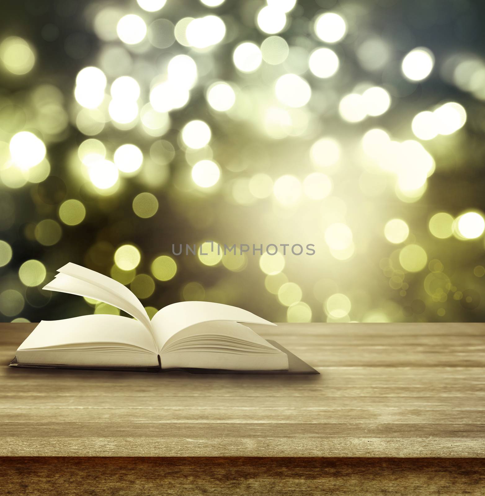 Open book on table in front of blurred lights