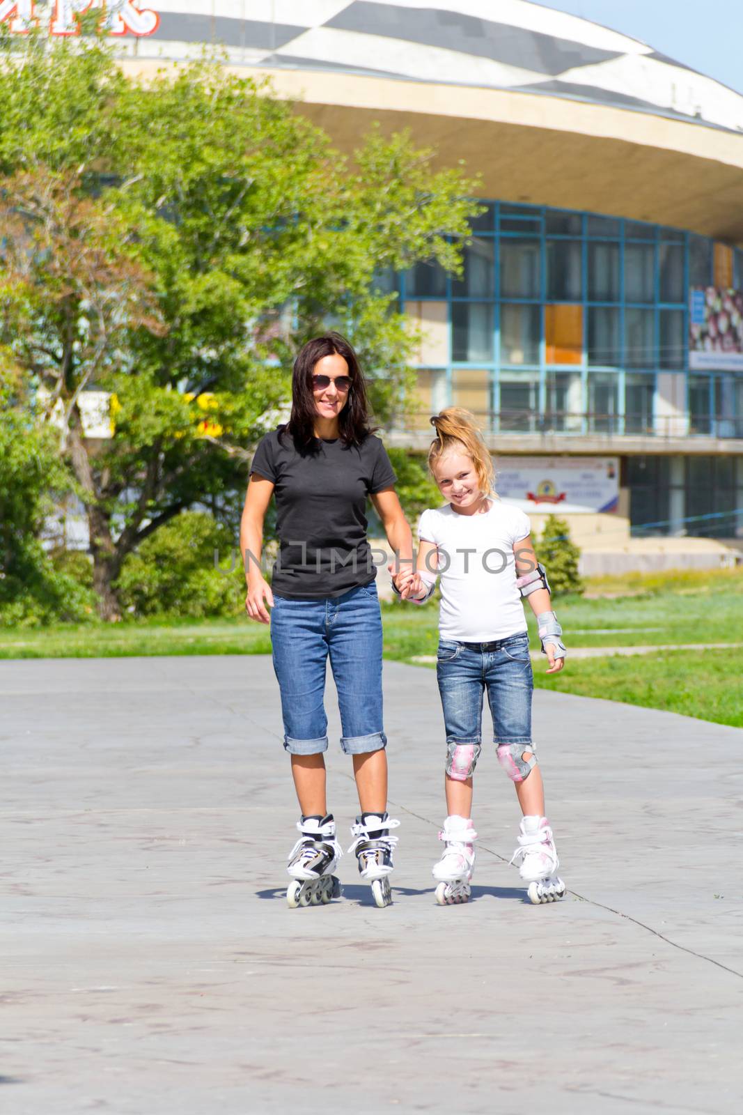 Photo of mother and daughter on roller skates in summer