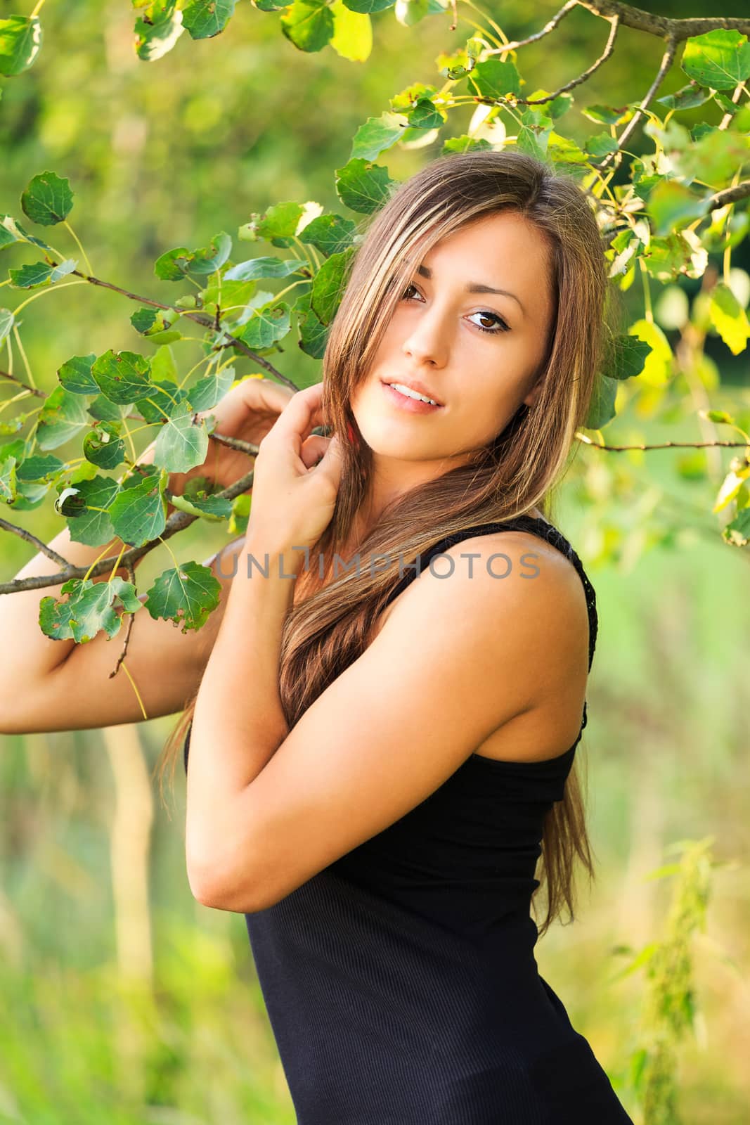 Portrait of smiling and charming lady woman girl outdoor with green background and black dress