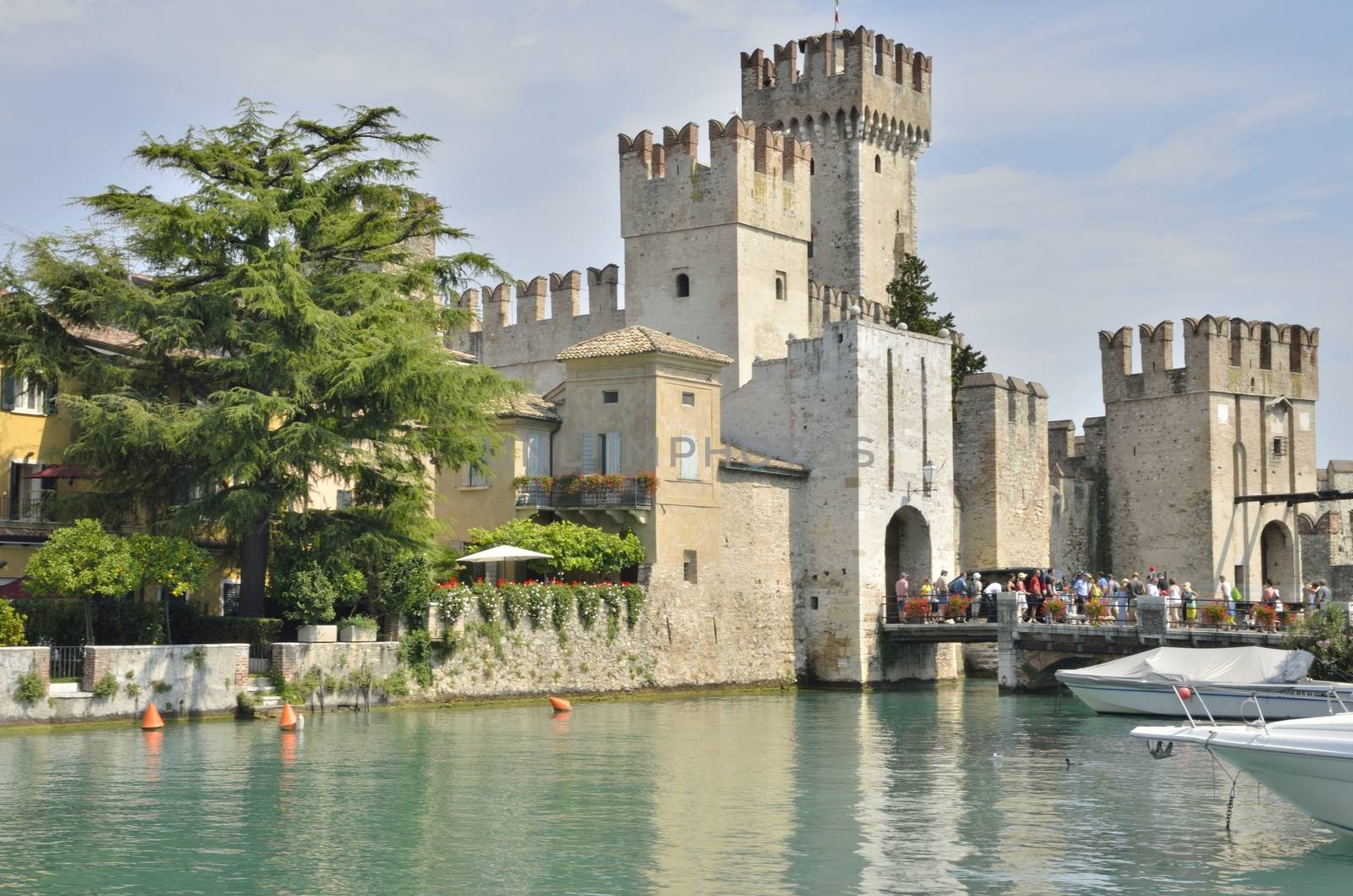 Tourists visiting the Scaliger Castle at Sirmione on lake Grada, Italy. The Castle was built in the 13th century.  This is a rare example of medieval port fortification, which was used by the Scaliger fleet.