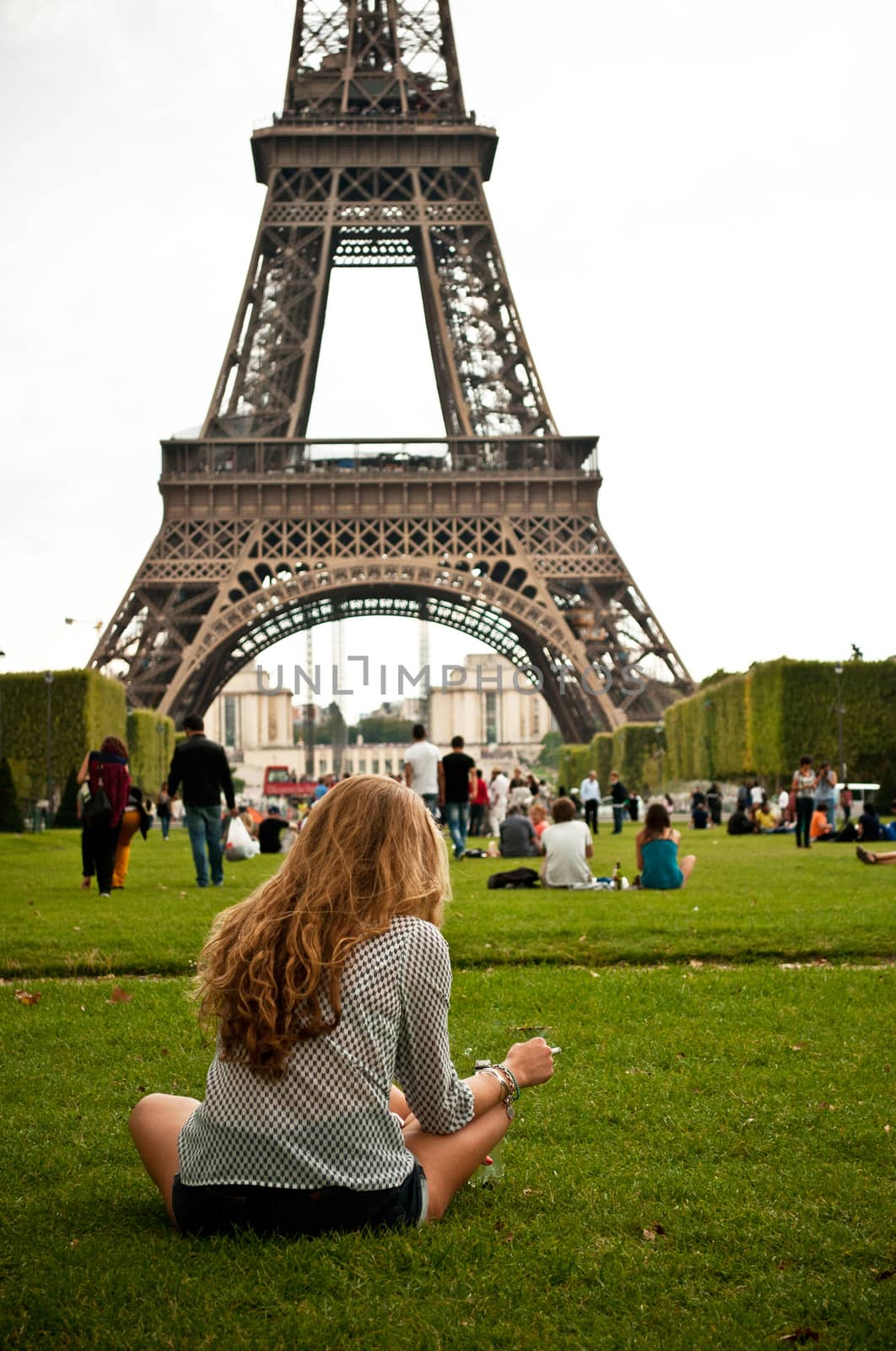 woman in Eiffel Tower in Paris by NeydtStock