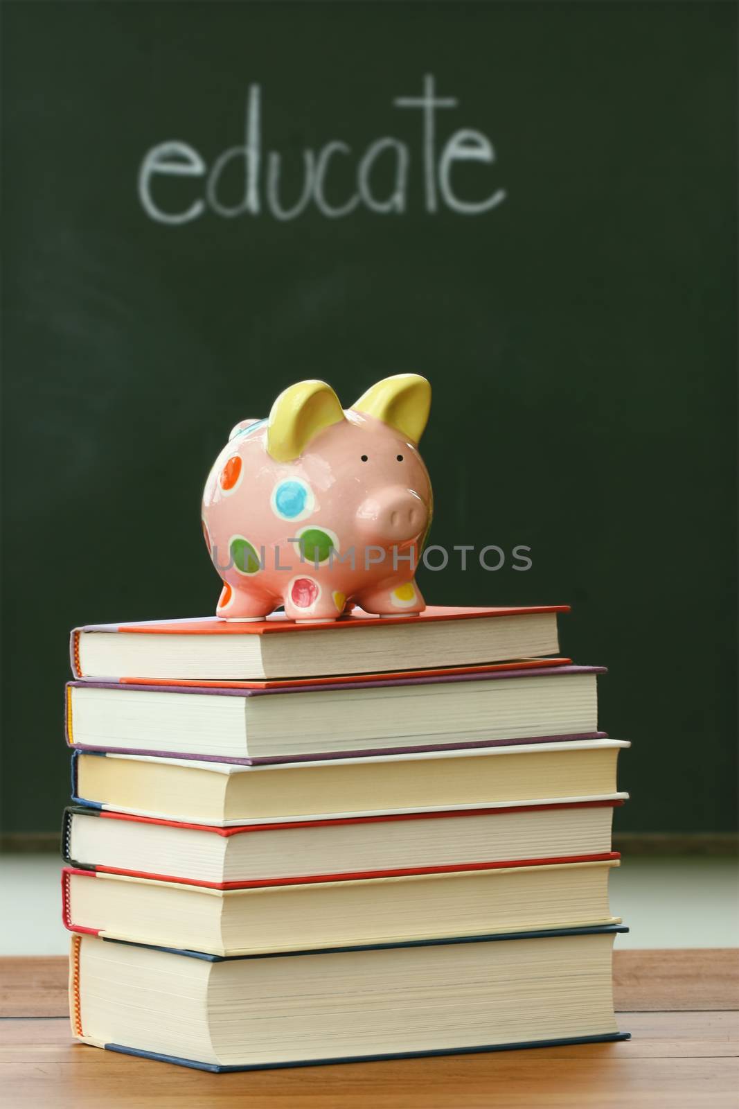 Piggy bank on a pile of books by Sandralise