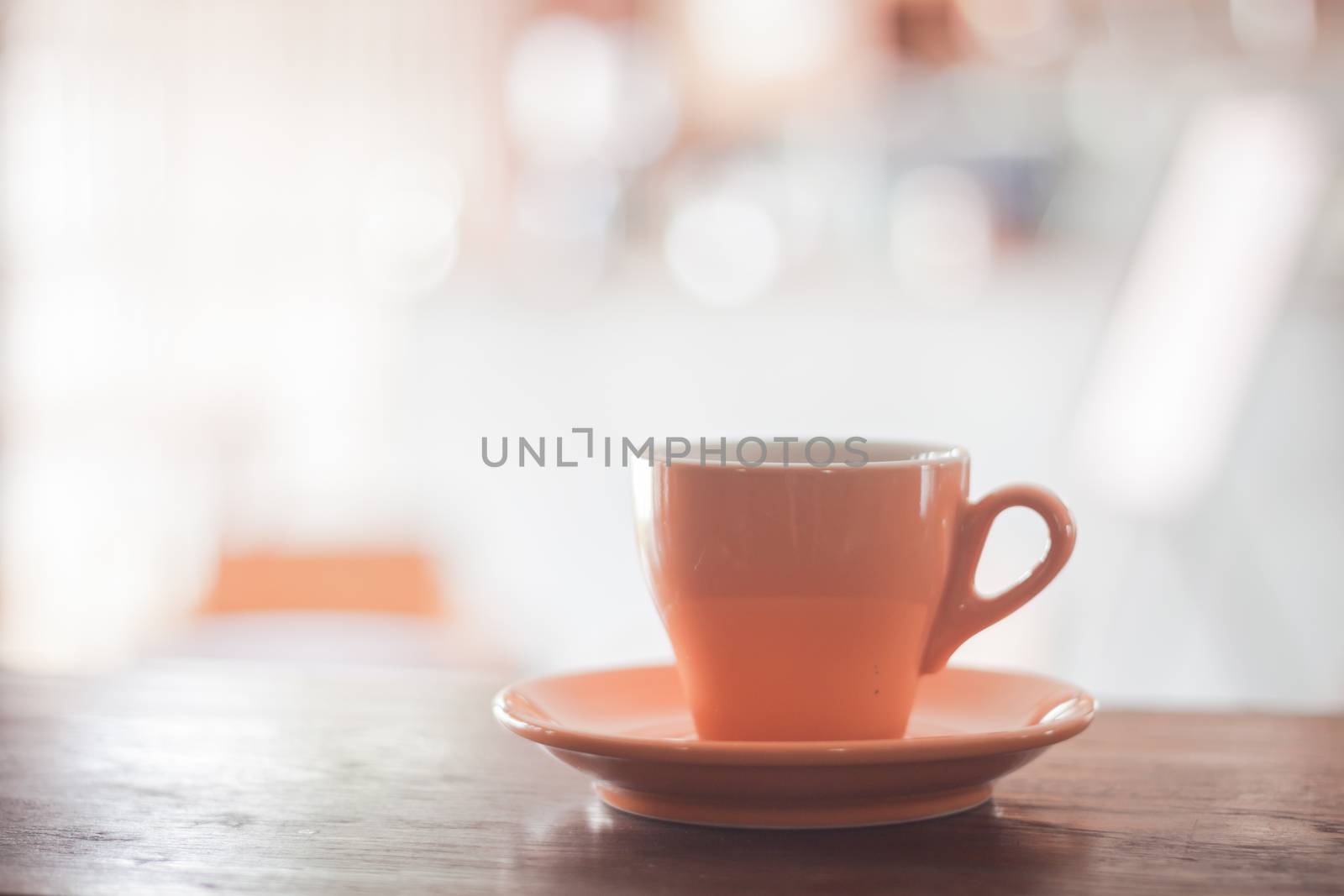 Orange coffee cup on wooden table by punsayaporn