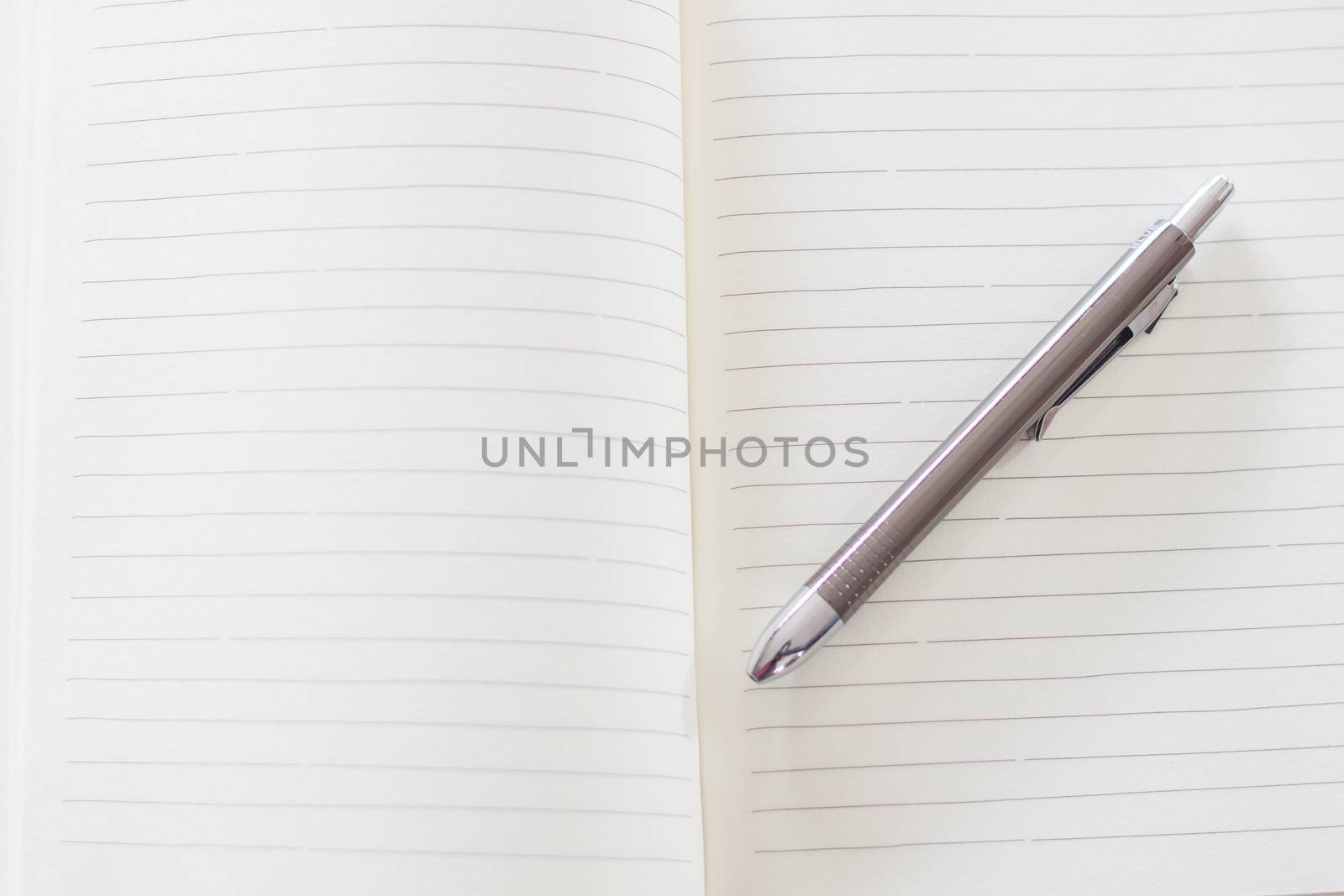 Open a blank white notebook and pen , stock photo