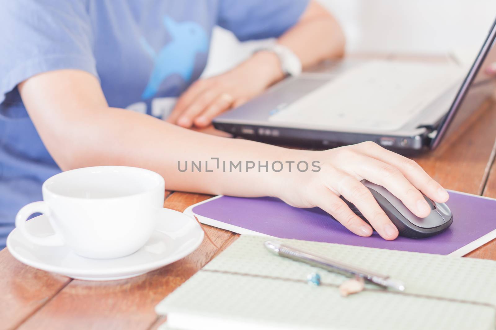 Woman working with laptop in coffee shop, stock photo