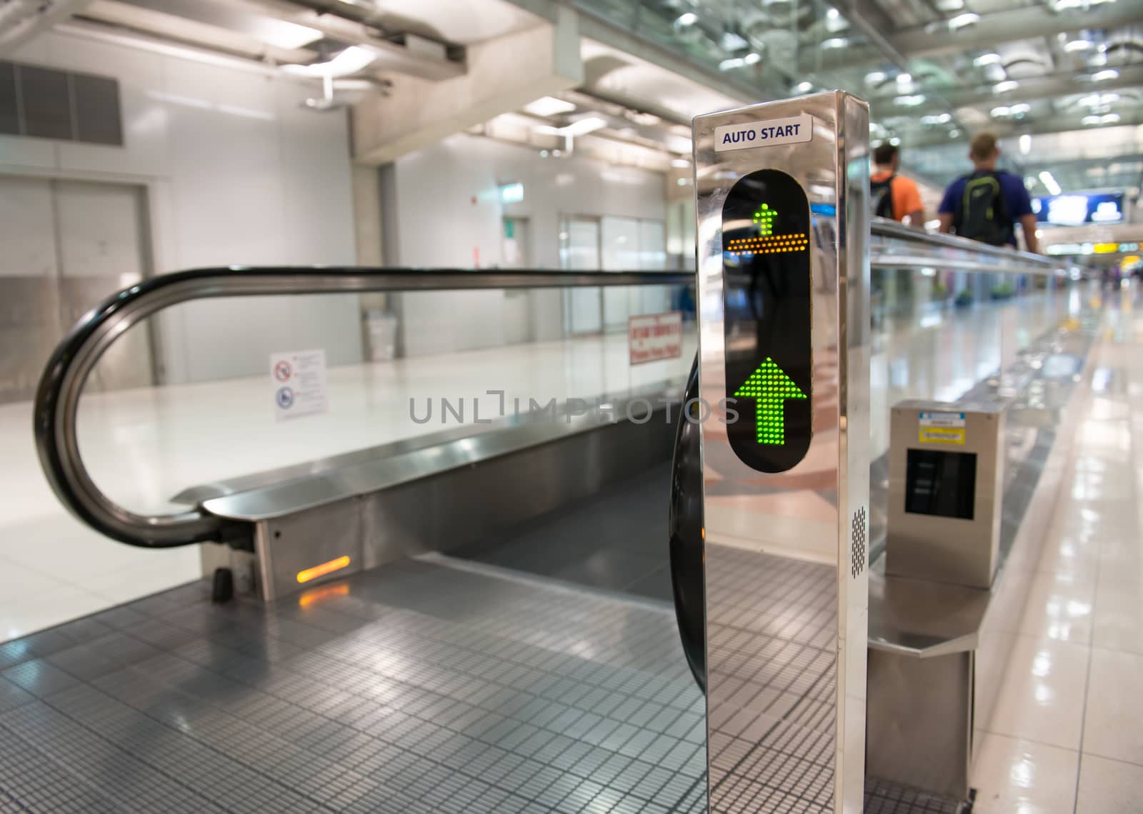 airport escalator with unrecognizable people walking on