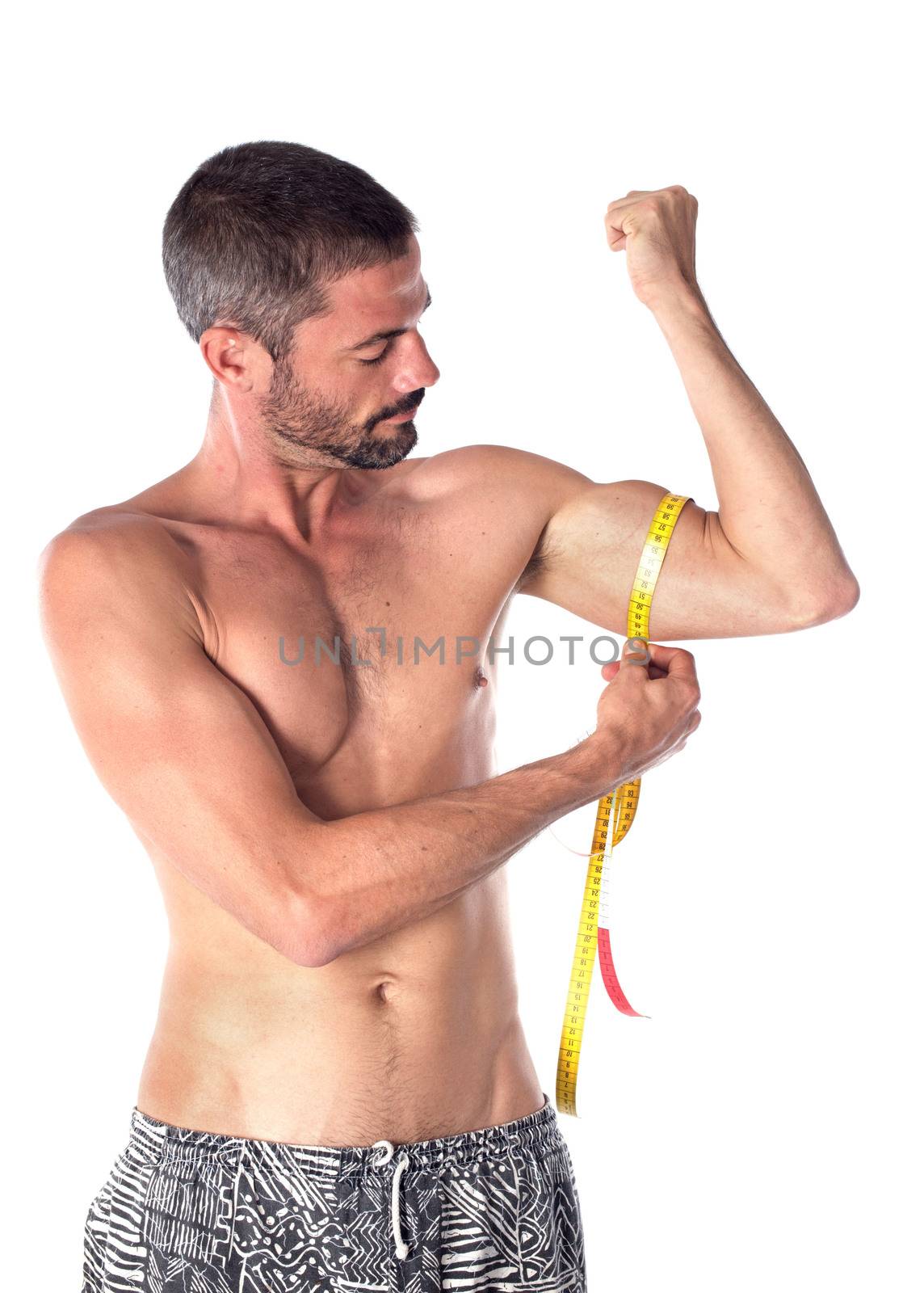 young man measuring in front of white background
