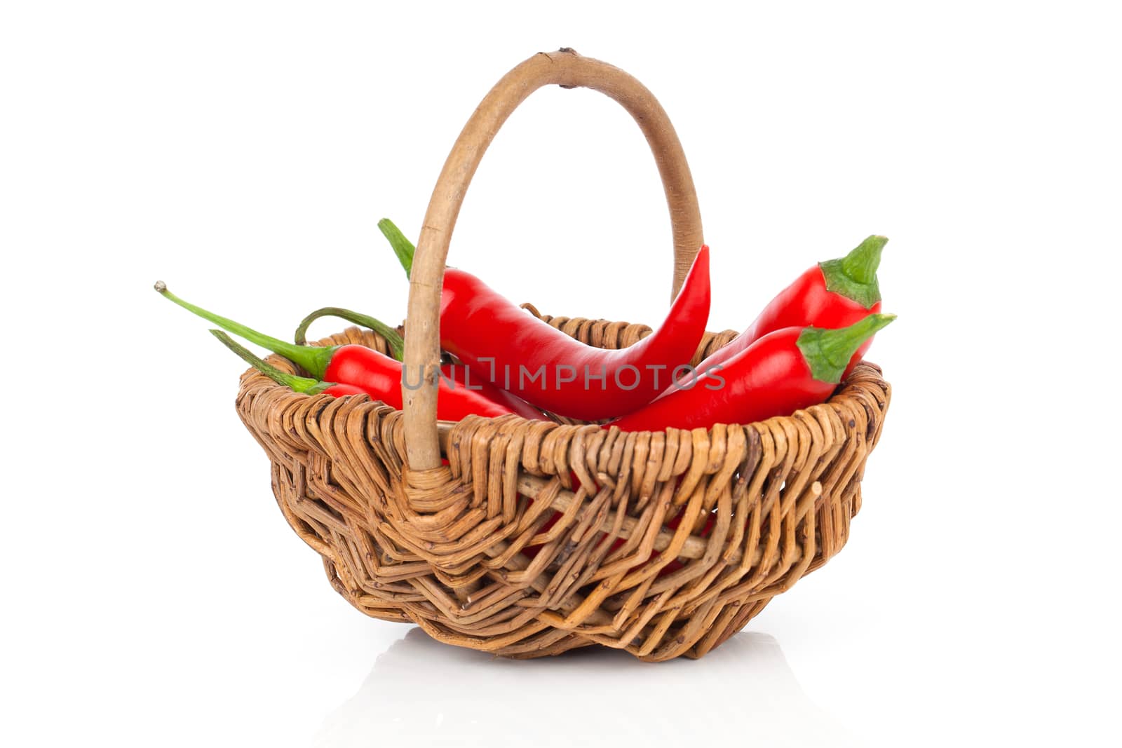 Red chili pepper in a wicker basket, isolated on white background