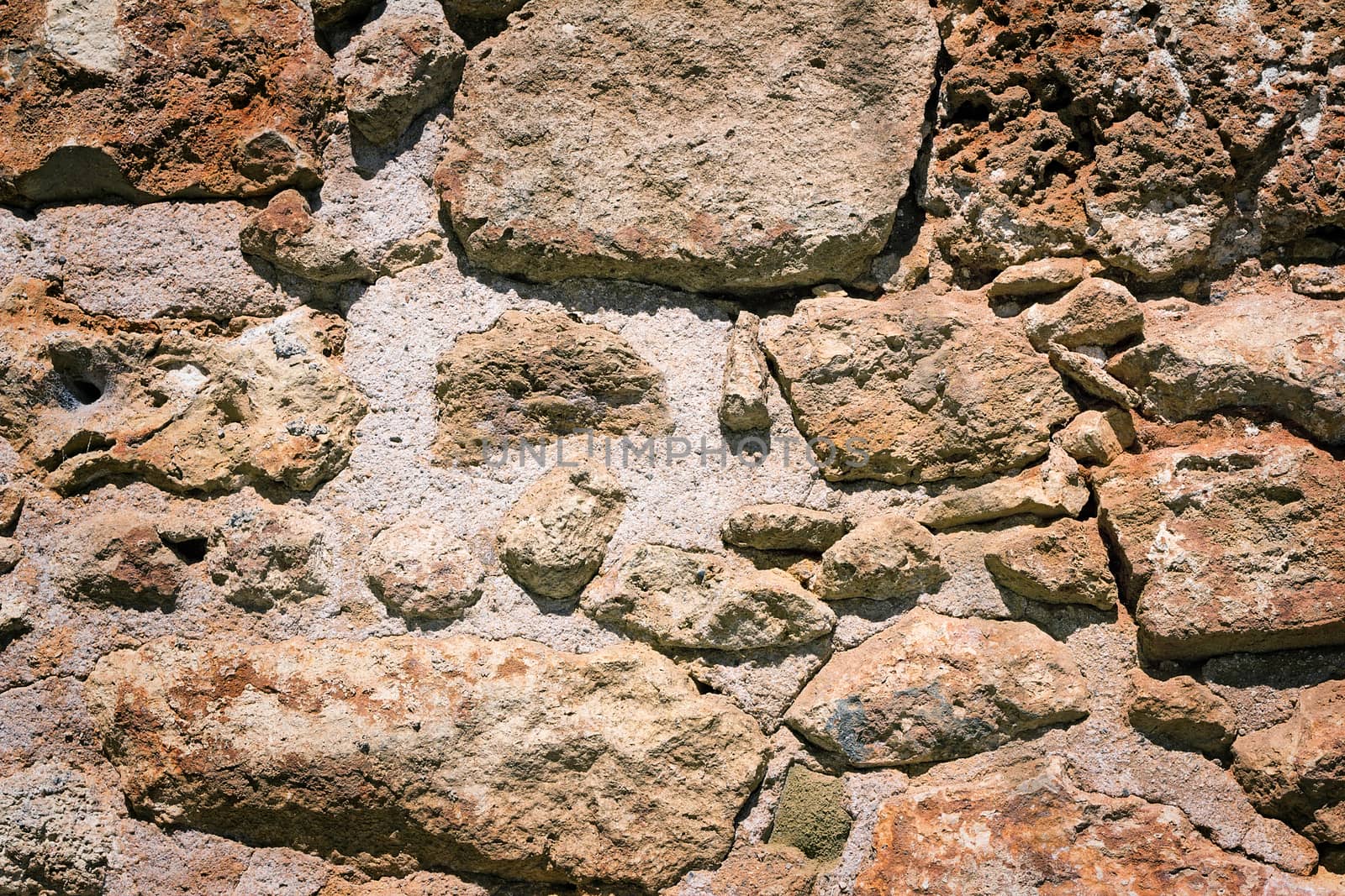 Fragment of the ancient stone wall executed from stones of various form and the size. Background image.