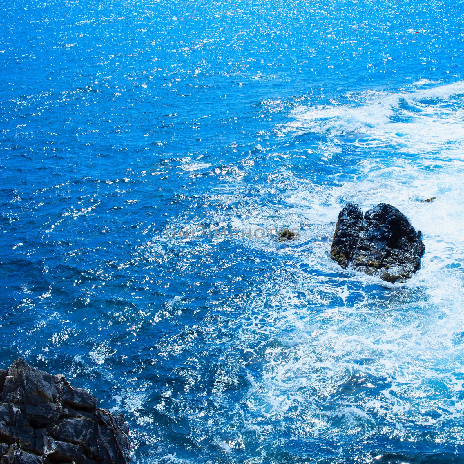 Rocks in the sea with foam, square image