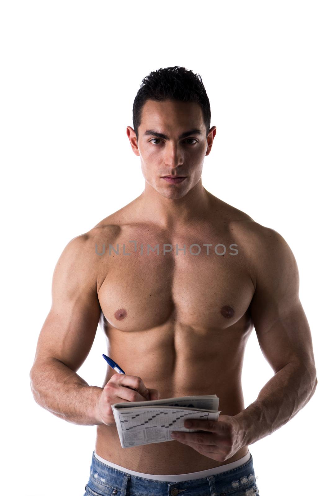 Shirtless attractive young man solving crosswords puzzles published in a printed magazine, portrait on white