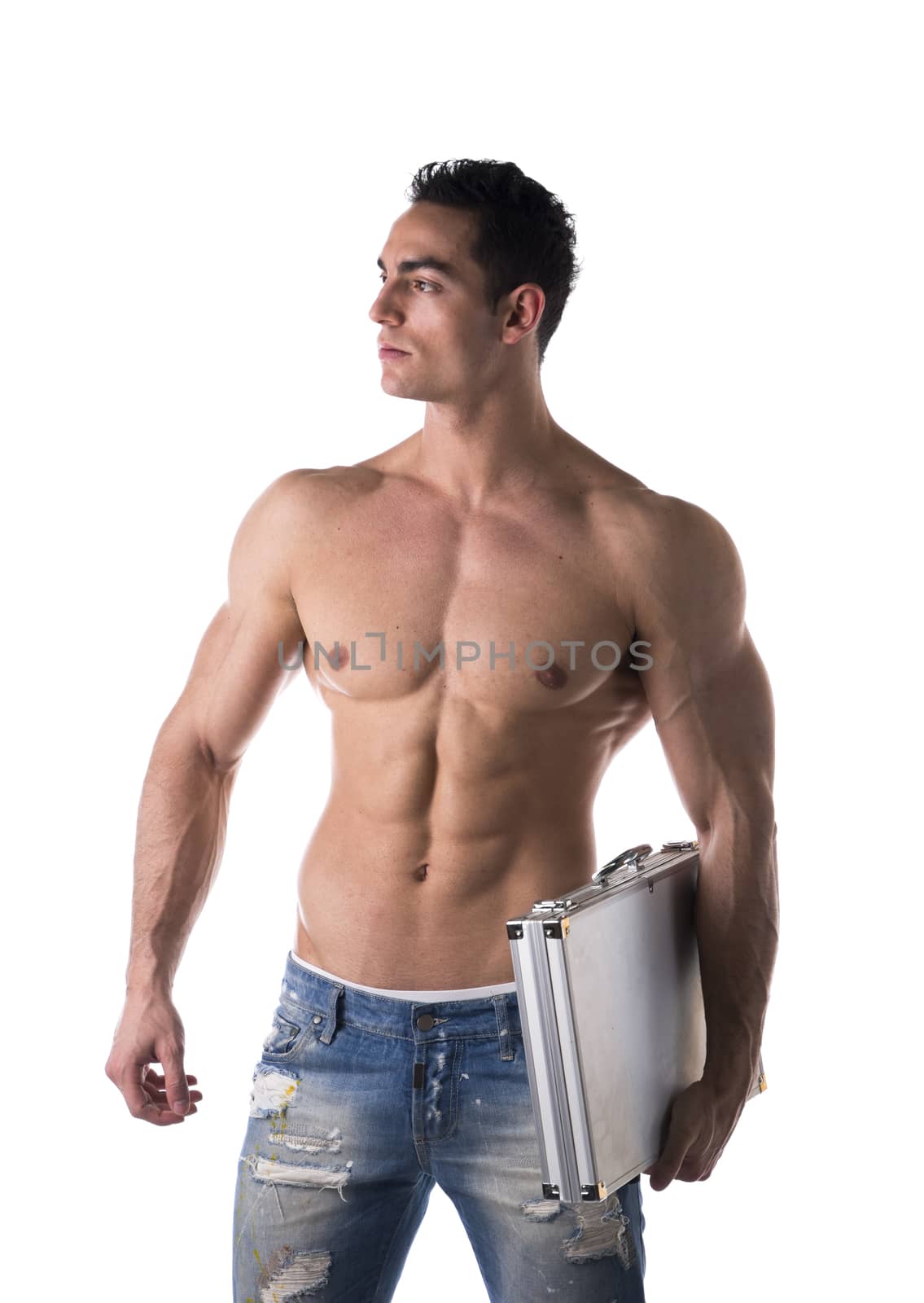 Shirtless handsome muscular young businessman with a strong physique standing looking away carrying a briefcase under his arm isolated on white