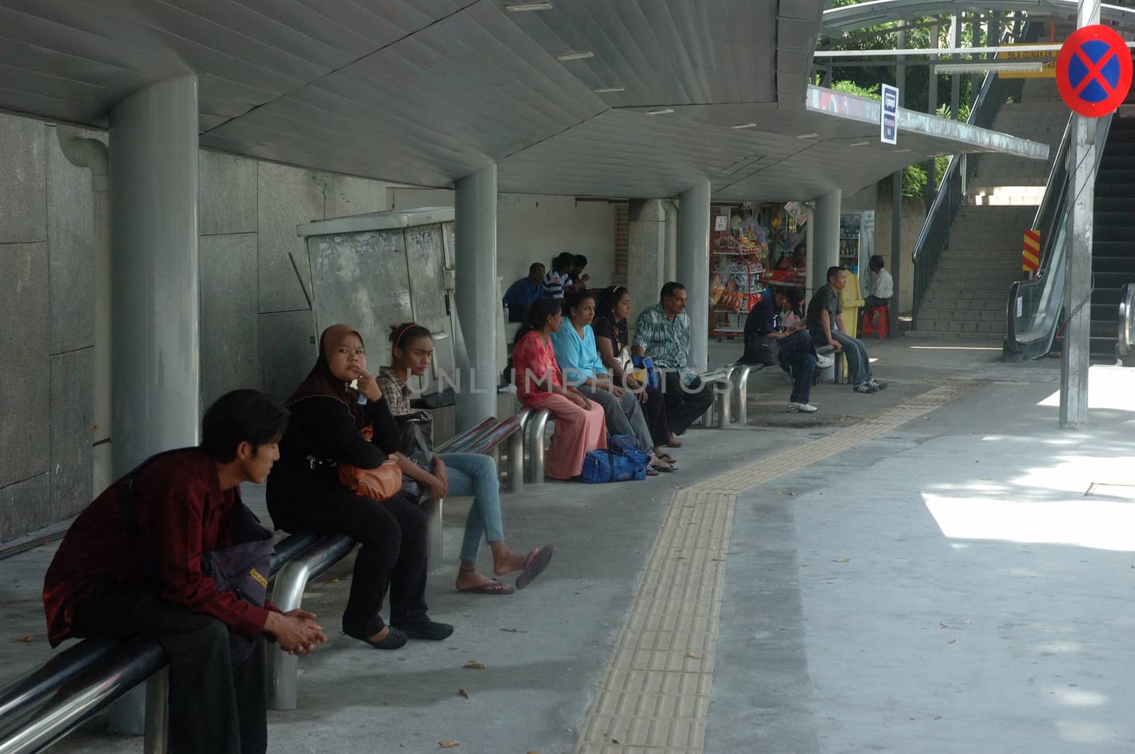 Kuala Lumpur, Malaysia - June 8, 2013: Malaysian people waiting for bus in shelter.