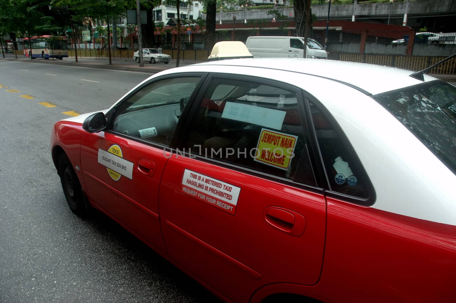 Kuala Lumpur, Malaysia - June 9, 2013: Red colored taxi that operated in Kuala Lumpur, Malaysia.