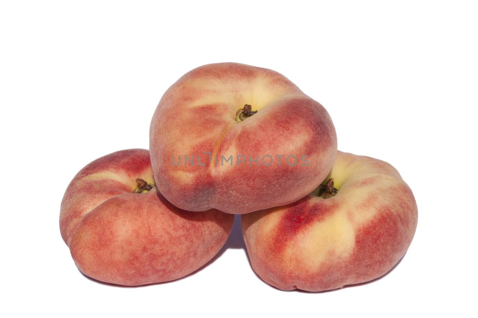Three sweet flat peaches on a white background