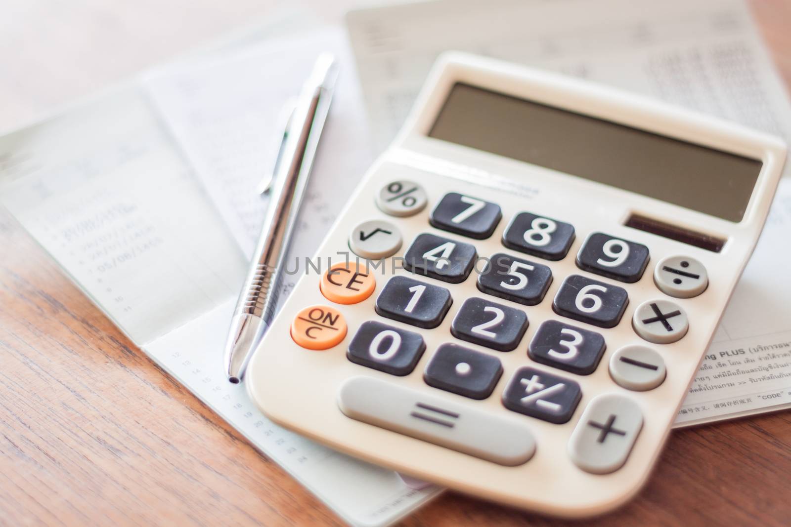 Calculator and pen on bank account passbook, stock photo