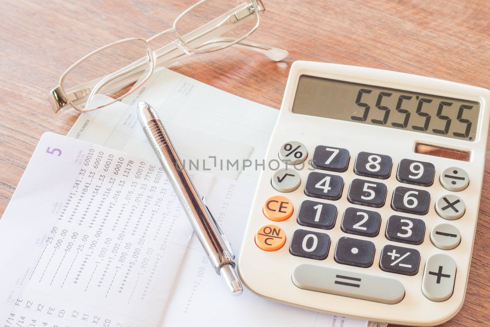 Calculator, pen and eyeglasses with bank account passbook, stock photo