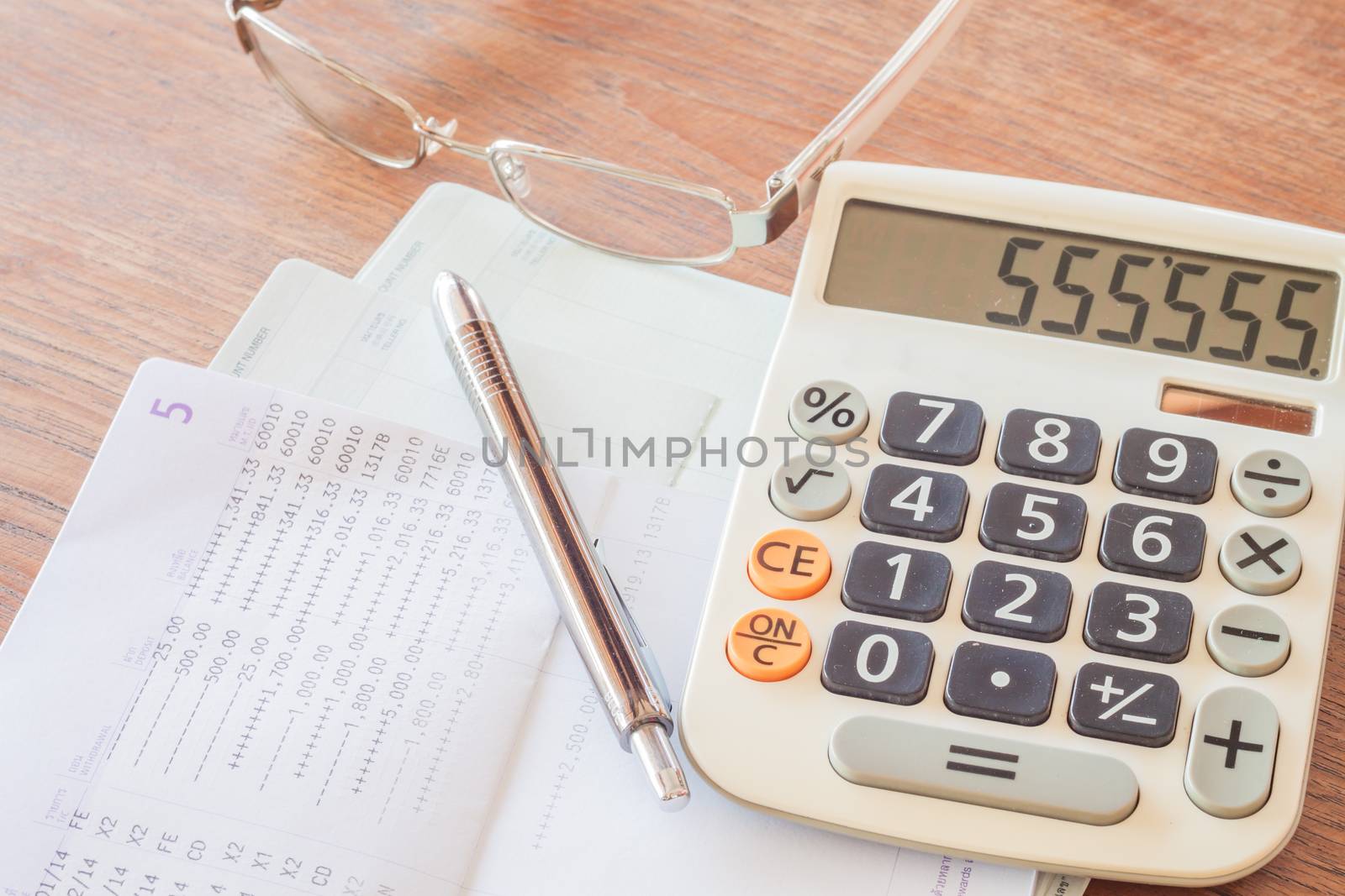 Calculator, pen and eyeglasses on bank account passbook, stock photo