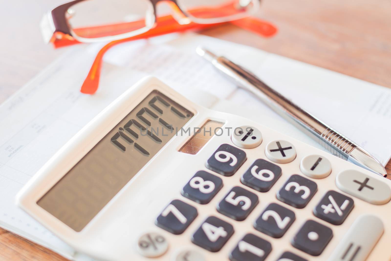 Calculator, pen and on bank account passbook by punsayaporn